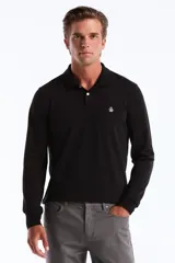 Polo de manga larga color negro, con cuello polo y tapeta de dos botones blancos. Presenta un pequeño logo bordado de pingüino en el pecho.