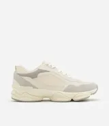 Championes dad sneaker grises con recortes en cuero sintético, cordones blancos y suela chunky de goma color crema.