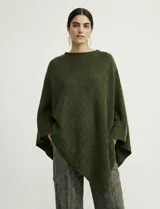 Poncho tejido de punto grueso, color mostaza/mostaza oscuro, con cuello redondo y caída amplia.