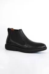 Bota Chelsea de cuero negro con elástico lateral y suela gruesa.