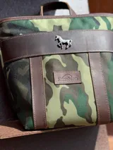 Mochila pequeña color borgoña con detalles en cuero marrón, asa de mano y correas ajustables.
