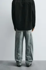 Pantalón de jean celeste de corte amplio con efecto lavado. Tiene cinco bolsillos y costuras frontales en las piernas.