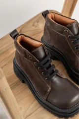 Borcegos negros de cuero charol, con punta cuadrada, cordones y suela track.