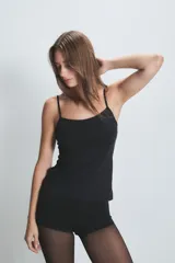 Musculosa blanca de microfibra liviana con breteles ultrafinos regulables y doble tejido en la zona del busto.