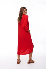 Vestido camisero rojo de corte midi, con cuello camisero, mangas 3/4 y cierre frontal con botones. Incluye bolsillos laterales.