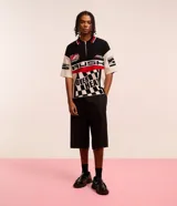 Camisa polo masculina de punto, corte boxy, con cuello con cremallera, manga corta y estampado estilo automovilismo con lettering.