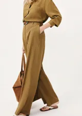 Pantalón de vestir color marrón, de corte recto y tiro alto, con bolsillos laterales y presillas para cinturón.
