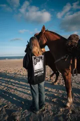 Buzo negro de corte holgado con estampa en la espalda con la leyenda 'Glassy Surfing 1999 Surf-Travel Club'.