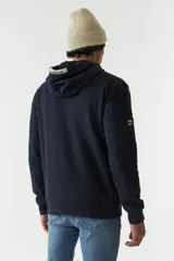 Canguro azul marino de felpa con capucha y cordones blancos. Presenta un estampado con una imagen de una escultura y texto en verde y blanco. Tiene bolsillos tipo canguro y puños y cintura acanalados.