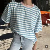 Remera de manga corta, corte holgado, con cuello redondo y ribete en color rosado. Estampada con rayas horizontales anchas en blanco y celeste.