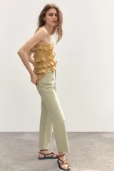 Jeans color verde claro de tiro alto, corte recto y largo tobillero. Diseño de cinco bolsillos y cierre frontal con cremallera y botón metálico.