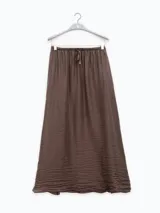 Falda larga marrón de tejido arrugado liviano, con cintura elástica y terminación Polonio en cobre.
