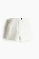 Short de vestir color blanco, de tiro alto, con bolsillos al bies y bolsillos insertados decorativos atrás. Presenta cierre frontal con botón.