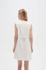 Vestido blanco de lino, corte entallado, con botones frontales, cuello a la base y breteles anchos.