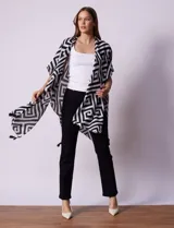 Kimono tejido con estampado geométrico en blanco y negro, con terminación de ruedo con borlas.