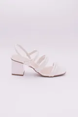 Sandalias de ecocuero charolado color negro, con punta cuadrada, dos tiras horizontales sobre el empeine, pulsera con hebilla al tobillo y taco cuadrado.