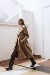 Bota alta de cuero color marrón, con caña recta y suela plana.