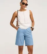 Bermuda regular de cintura alta, confeccionada en jeans, con cintura sastre, trabillas en la cintura y cierre tradicional.