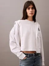 Remera blanca de algodón con cuello redondo y logo CK bordado en el pecho. Corte cropped y mangas cortas.