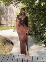 Vestido largo marrón de tejido de algodón fino y ligero, con mangas largas y escote redondo. Puede usarse con el escote hacia adelante o hacia atrás.