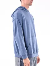 Hoodie gris claro de corte holgado, con capucha y bolsillo tipo canguro. Confeccionado en algodón.