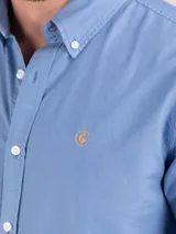 Camisa celeste de algodón con cuello abotonado, manga larga con puños abotonados y logo bordado en el pecho. Corte regular fit y teñido garment dyed para un acabado vintage.