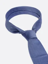 Corbata azul con pequeños lunares azul marino, confeccionada en seda texturizada.