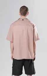 Camisa color beige de manga corta con calce oversize y canesú en la espalda.
