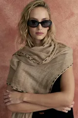 Pashmina color beige con pespuntes negros en los bordes.