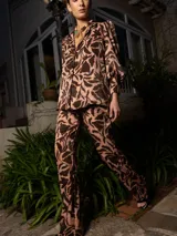 Pantalón de vestir de tiro alto, color beige con estampado de hojas marrones.