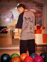 Remera gris con mangas raglán negras y estampado de Goofy y Pluto.