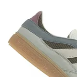 Zapatillas Adidas Handball Spezial ST en tonos gris, verde oliva y blanco. Confeccionadas en gamuza y material textil, con las tres tiras laterales en blanco y suela de goma color caramelo.