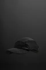 Gorra negra de cinco paneles de tejido técnico con perforaciones, ajuste con elástico en la parte posterior y logo estampado.