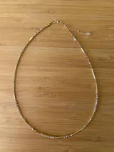 Gargantilla dorada con cuentas de cristal facetado color champagne y tubos dorados.