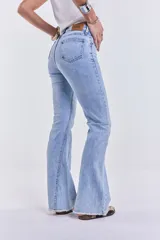 Pantalón de jean celeste de tiro medio, corte ajustado hasta la rodilla y acampanado en la parte inferior, con lycra y terminación desflecada.