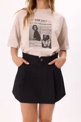 Remera negra oversize de algodón con estampado frontal estilo editorial.