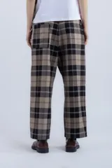 Pantalón de vestir con corte recto y tiro medio, con cintura elástica y bolsillos laterales. Diseño a cuadros en tonos marrón, beige y negro.