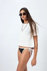 Bottom de bikini negro con tiras ajustables a los costados y bordes blancos en contraste.
