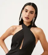 Mono corto negro de sastrería en crepé, con escote halter cruzado, busto marcado y abertura en el abdomen.