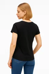 Remera negra de algodón con cuello en V y estampado de flores blancas.
