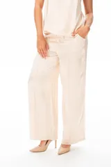 Pantalón de vestir color beige, de corte palazzo y tiro alto, con bolsillos laterales y pinzas frontales.
