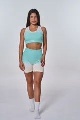 Conjunto deportivo de top y short color verde agua con degradé a blanco. El top es de corte racer-back y tiene el logo "bk." estampado en el frente. El short es de tiro alto.