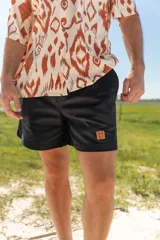 Bermuda de pana negra con logo bordado en color ocre en el lateral.