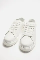 Zapatillas deportivas blancas con detalle en color gris en el talón y suela con plataforma.