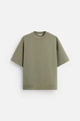 Sudadera verde oliva de corte holgado confeccionada en tejido interlock de algodón con elasticidad. Cuello redondo, manga corta y bajo con terminación en rib.