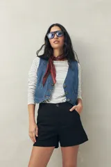 Short negro de tiro medio, con calce al cuerpo y dobladillos en los bordes.