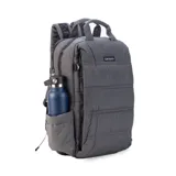 Mochila gris capitoneada con asa y correas regulables. Doble cierre principal, bolsillo al frente con apertura vertical y bolsillo trasero pequeño. Espacio para laptop de 15 pulgadas y correas ocultables.