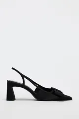 Zapato destalonado negro con tacón ancho y tira trasera. Detalle de lazo en la parte delantera.