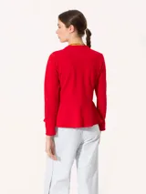 Chaqueta roja de tramado pesado con estructura y caída. Acceso mediante cierre en delantero y volados en la parte inferior.