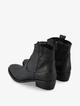 Botín de cuero negro de estilo texano con punta fina y costuras decorativas.